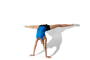 Image showing Beautiful young female athlete stretching on white studio background with shadows