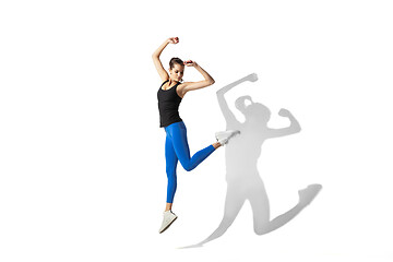 Image showing Beautiful young female athlete stretching on white studio background with shadows