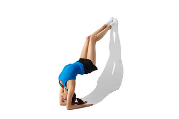Image showing Beautiful young female athlete stretching on white studio background with shadows