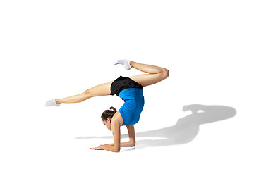 Image showing Beautiful young female athlete stretching on white studio background with shadows