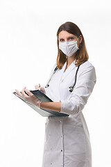 Image showing Girl doctor makes notes in the medical history on a tablet