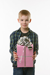 Image showing A boy holds a birthday gift in his hands