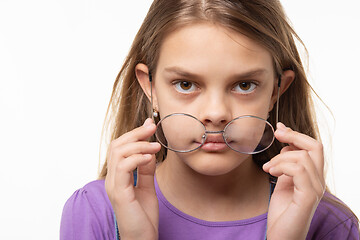 Image showing Teen girl takes off glasses, close up