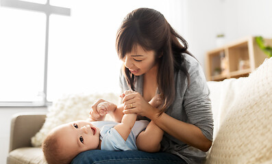 Image showing happy young mother with little baby son at home