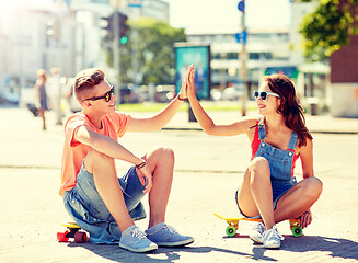 Image showing teenage couple with skateboards on city street