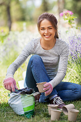 Image showing woman filling pots with soil at summer garden