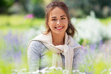 Image showing young woman with flowers at summer garden