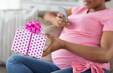 Image showing african pregnant woman with smartphone and gift