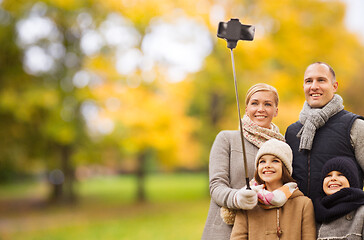 Image showing happy family with smartphone and monopod in park