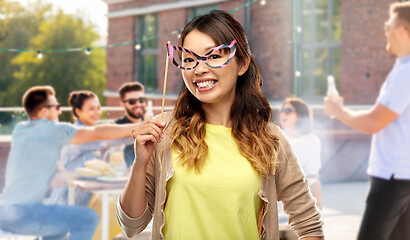 Image showing asian woman with big party glasses over rooftop