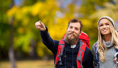 Image showing smiling couple with backpacks hiking in autumn