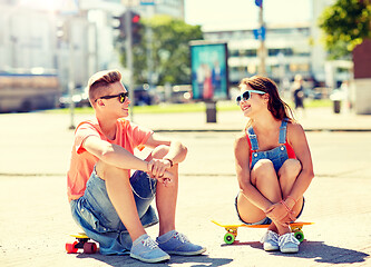 Image showing teenage couple with skateboards on city street