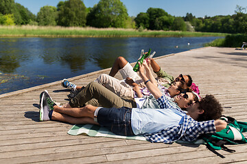 Image showing friends drinking beer and cider on lake pier