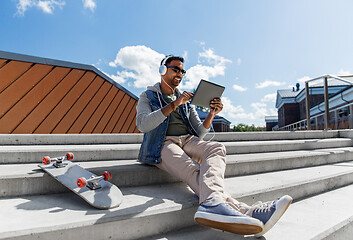 Image showing man with tablet pc and headphones on roof top