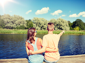 Image showing happy couple pointing finger on summer river berth