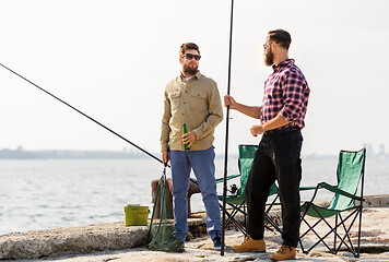 Image showing male friends with fishing rods and beer on pier