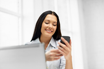 Image showing businesswoman using smartphone at office