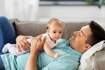 Image showing middle aged father with baby lying on sofa at home