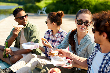 Image showing happy friends having picnic on lake pier in summer