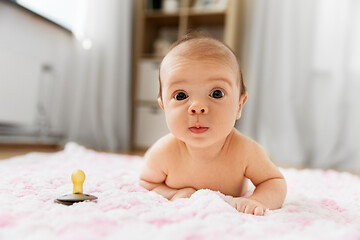 Image showing baby girl in diaper lying with pacifier on blanket