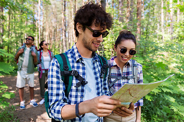 Image showing friends with map and backpacks hiking in forest