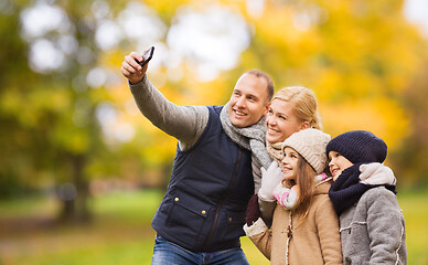 Image showing happy family with camera in autumn park