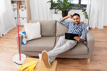 Image showing man with tablet computer after home cleaning