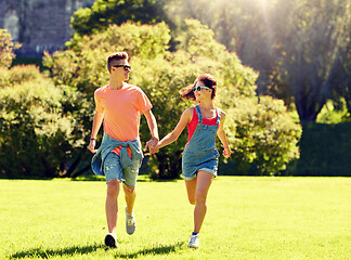 Image showing happy teenage couple running at summer park