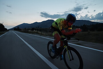 Image showing triathlon athlete riding bike at night