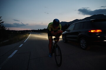 Image showing triathlon athlete riding bike at night