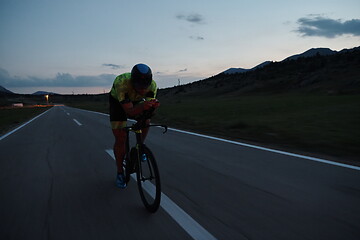 Image showing triathlon athlete riding bike at night