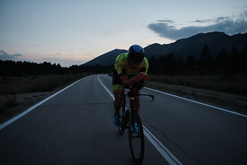 Image showing triathlon athlete riding bike at night