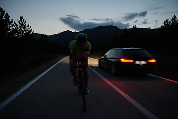 Image showing triathlon athlete riding bike at night