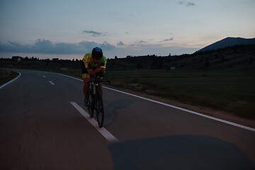 Image showing triathlon athlete riding bike at night