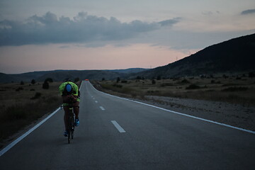 Image showing triathlon athlete riding bike at night