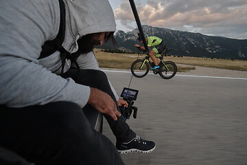 Image showing cinematographer taking action shot of triathlon bike athlete