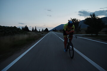 Image showing triathlon athlete riding bike at night