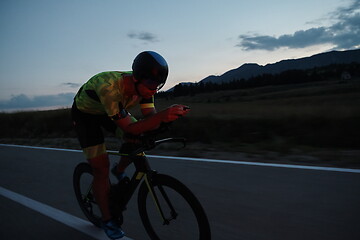 Image showing triathlon athlete riding bike at night