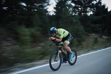 Image showing triathlon athlete riding bike at night