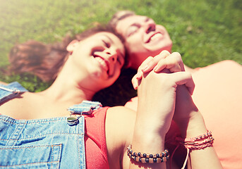 Image showing happy teenage couple lying on grass at summer