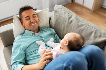 Image showing middle aged father with baby lying on sofa at home