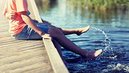 Image showing happy teenage couple sitting on river berth