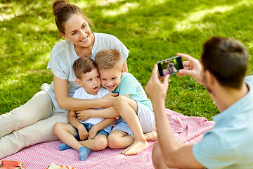 Image showing father taking picture of family on picnic at park