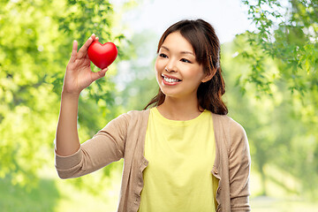Image showing asian woman with red heart over natural background