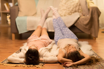 Image showing female friends lying on floor at home pajama party