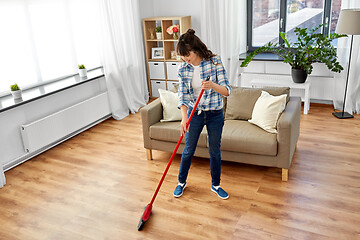 Image showing asian woman with broom sweeping floor and cleaning