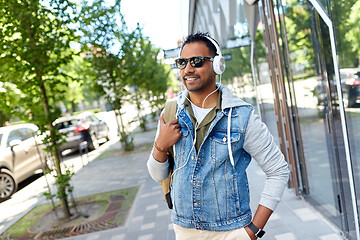 Image showing indian man in headphones with backpack in city