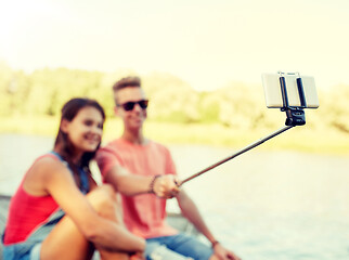 Image showing happy teenage couple taking selfie on smartphone