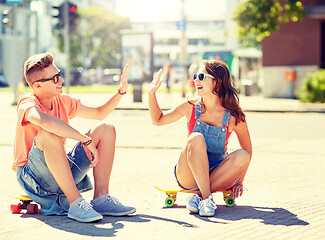 Image showing teenage couple with skateboards on city street