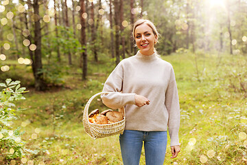 Image showing woman with basket picking mushrooms in forest